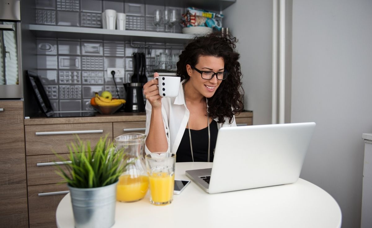 happy woman with a laptop drinking coffee
