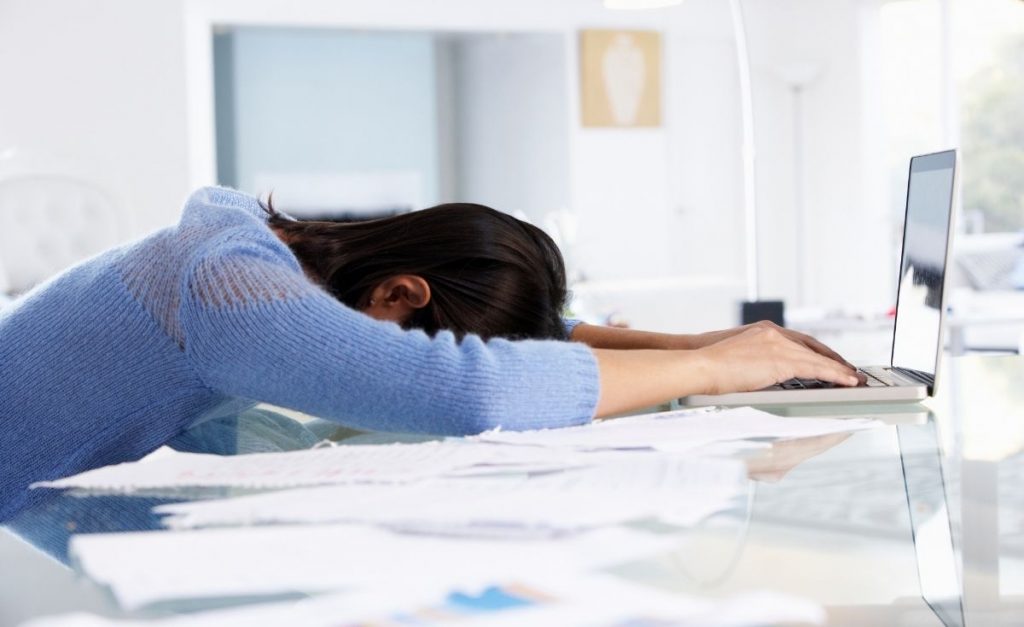 photo of an overwhelmed woman sitting at a desk